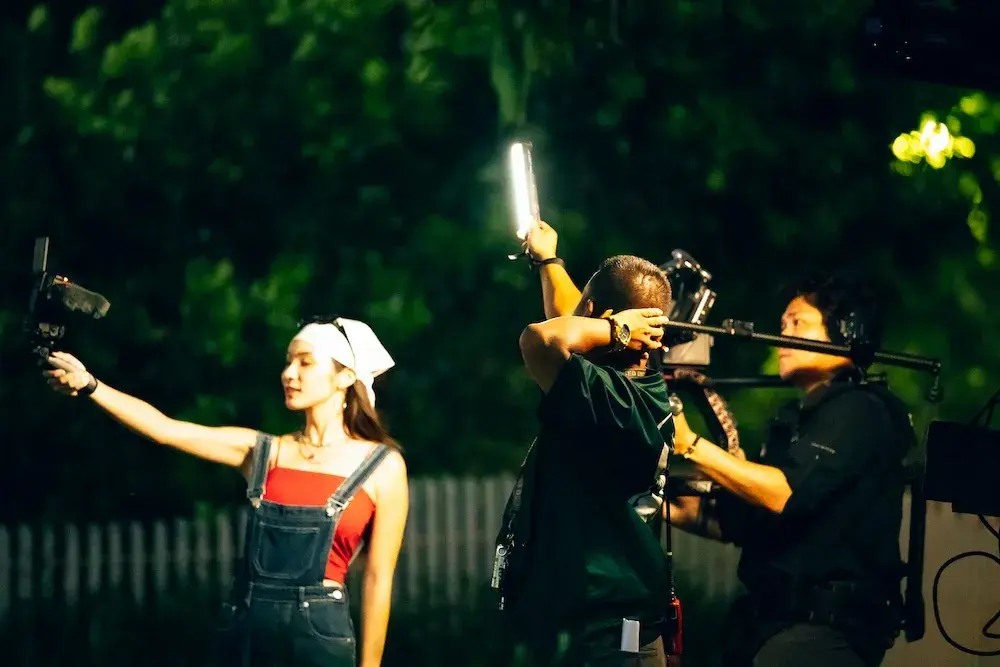 ทีมงานถือไฟ Nanlite PavoTube กับนักแสดงสวมหมวกผ้าสีขาว