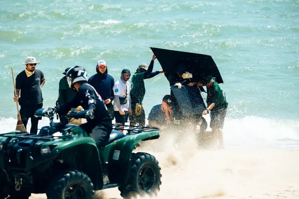 กองถ่ายบนชายหาด ทีมงานถือ Black Flag กันแสง มี ATV